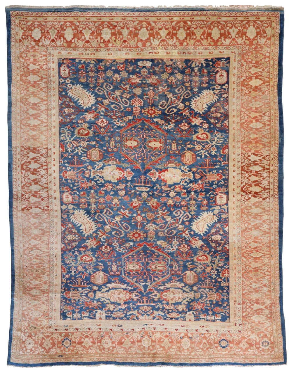An antique hand-knotted Persian Ziegler carpet featuring a deep indigo blue central field decorated with ivory and terracotta floral motifs inside a wide terracotta border.