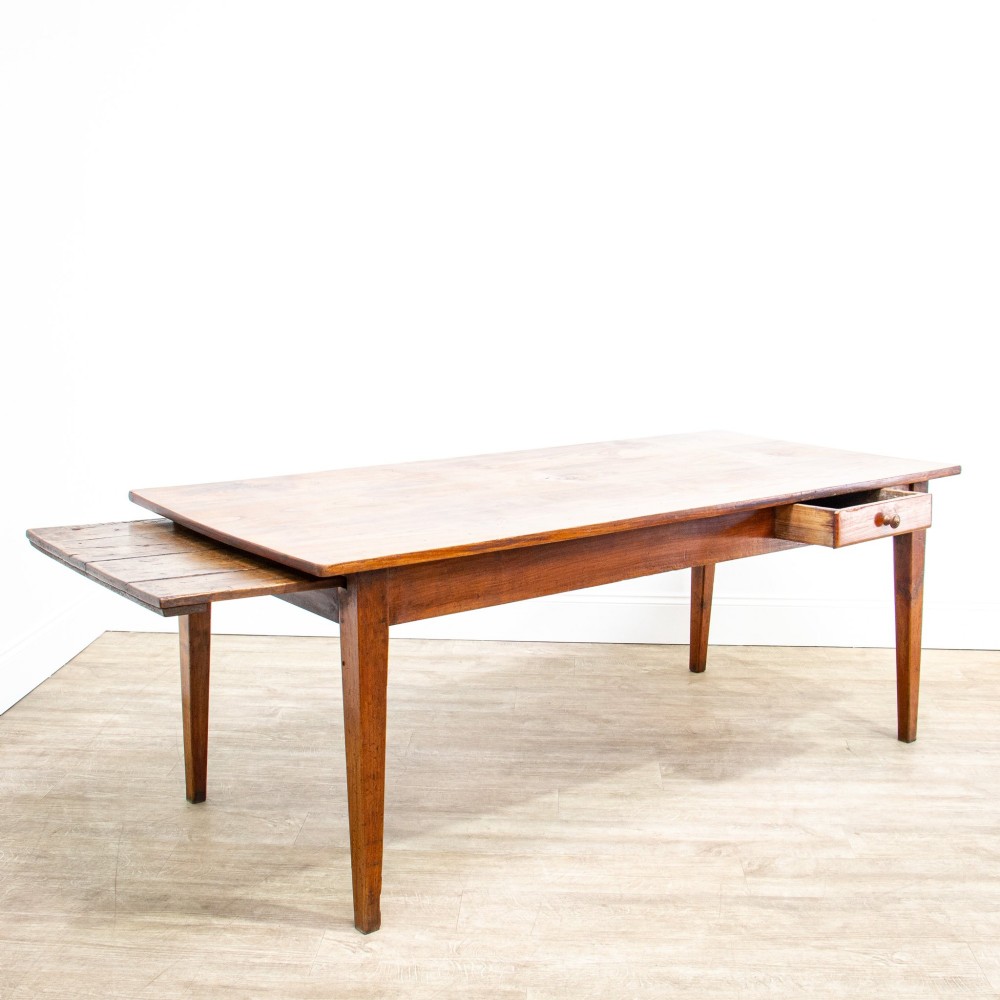 A 19th-century French fruitwood farmhouse dining table featuring a rectangular plank top, tapered square legs, and a single frieze drawer. View III