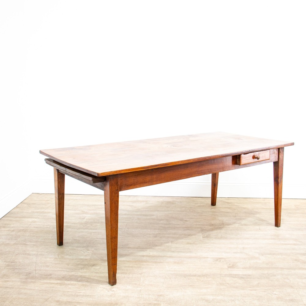 A 19th-century French fruitwood farmhouse dining table featuring a rectangular plank top, tapered square legs, and a single frieze drawer. View IV