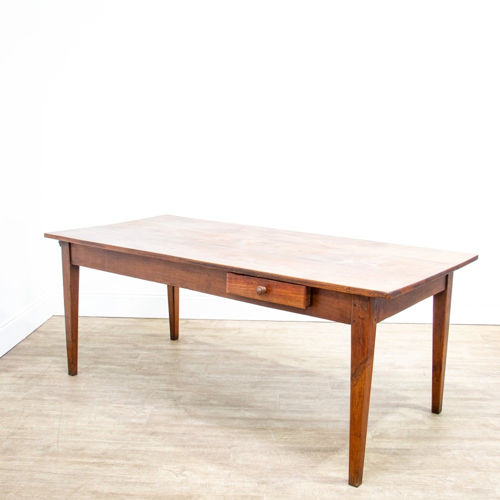 A 19th-century French fruitwood farmhouse dining table featuring a rectangular plank top, tapered square legs, and a single frieze drawer. View V