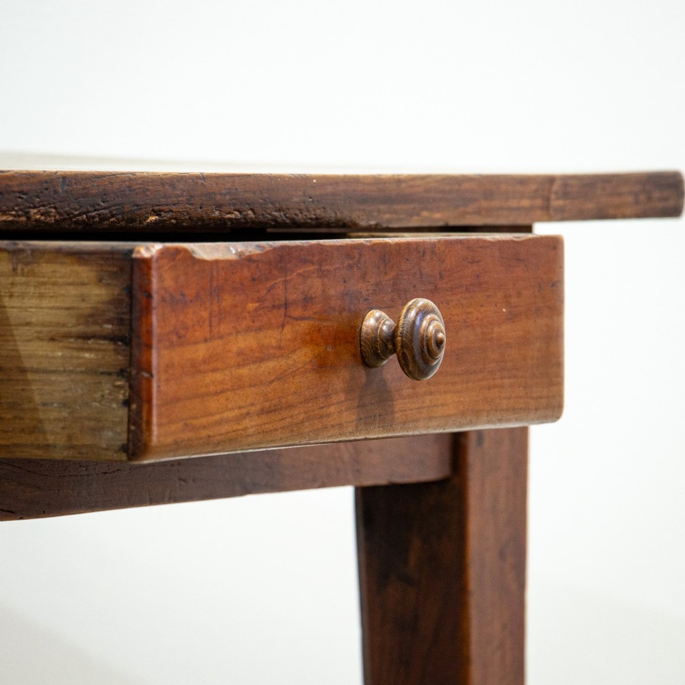 A 19th-century French fruitwood farmhouse dining table featuring a rectangular plank top, tapered square legs, and a single frieze drawer. View IX