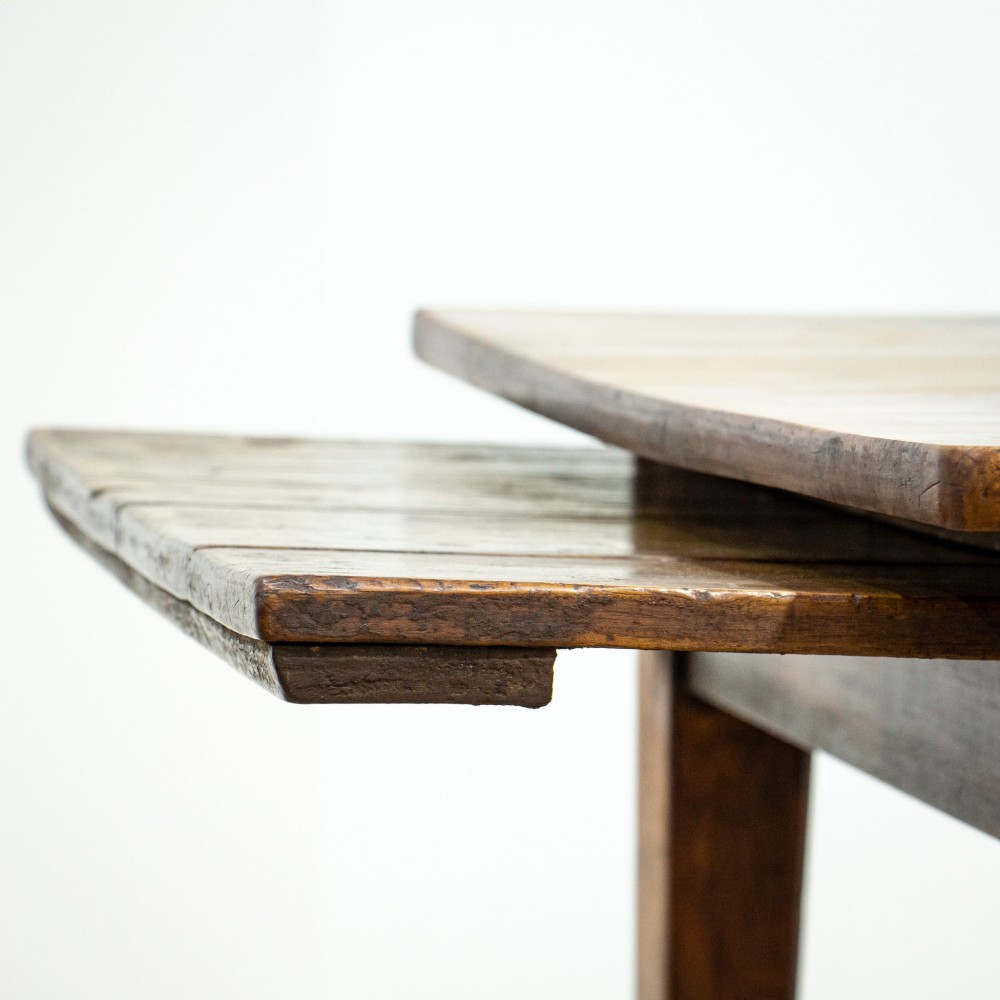 A 19th-century French fruitwood farmhouse dining table featuring a rectangular plank top, tapered square legs, and a single frieze drawer. View X