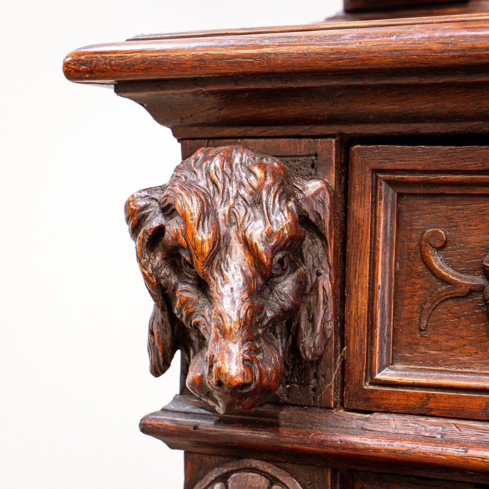 A 19th-century French dark oak two-tier hunting cabinet featuring glazed upper doors and deeply carved lower panels depicting game birds. View V