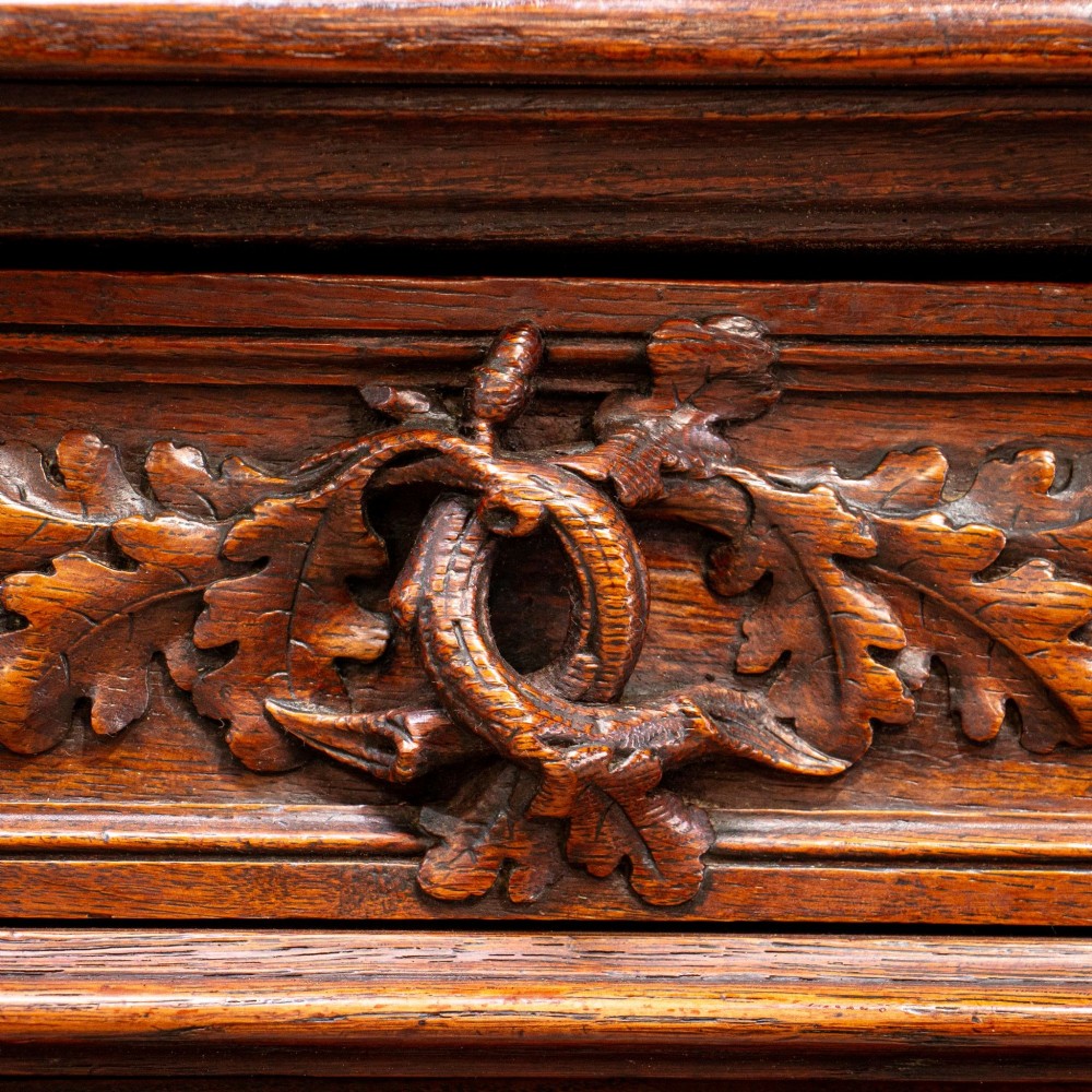 A 19th-century French dark oak two-tier hunting cabinet featuring glazed upper doors and deeply carved lower panels depicting game birds. View VII