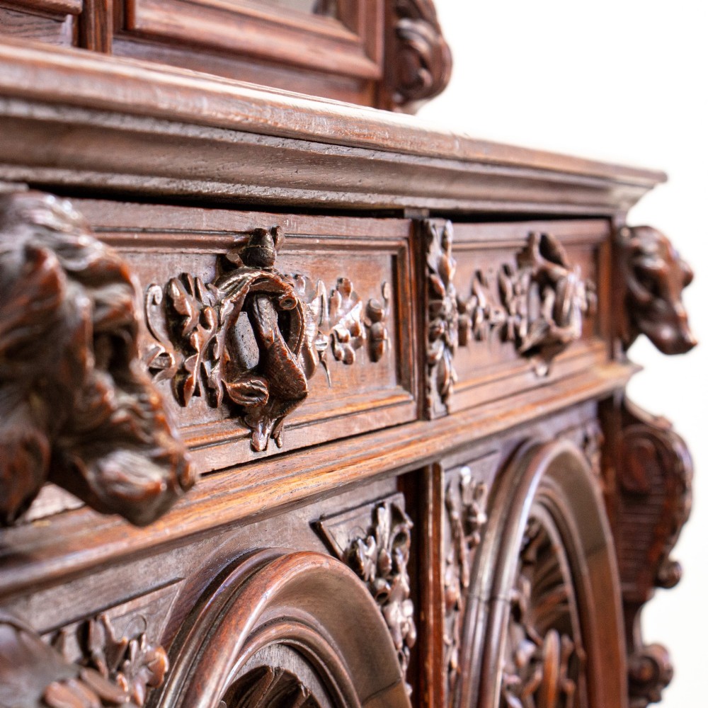 A 19th-century French dark oak two-tier hunting cabinet featuring glazed upper doors and deeply carved lower panels depicting game birds. View VIII
