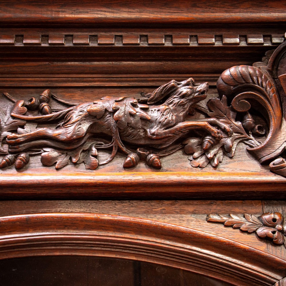 A 19th-century French dark oak two-tier hunting cabinet featuring glazed upper doors and deeply carved lower panels depicting game birds. View XIII