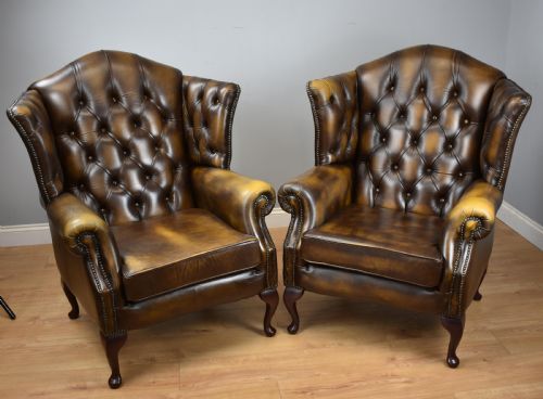 Pair 20th Century Buttoned back leather wing back Arm chairs