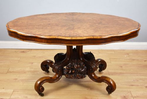 fig 1. A Victorian tilt-top loo table shown vertically, featuring quarter-matched burr walnut veneer with a scalloped edge on carved cabriole legs.