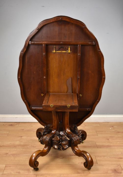 fig 2. A Victorian tilt-top loo table shown vertically, featuring quarter-matched burr walnut veneer with a scalloped edge on carved cabriole legs.