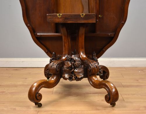 fig 3. A Victorian tilt-top loo table shown vertically, featuring quarter-matched burr walnut veneer with a scalloped edge on carved cabriole legs.