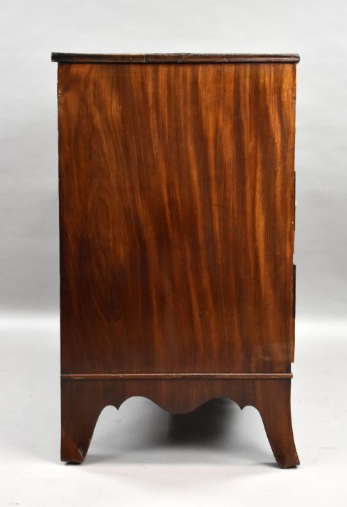 fig 2. A Regency mahogany chest of drawers featuring three full-length drawers with brass knobs, bone keyhole escutcheons, flame veneer fronts, and a shaped apron base.