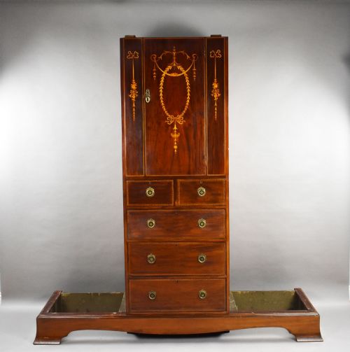 fig 1. An Edwardian mahogany triple wardrobe featuring twin full-length mirror doors flanking a central inlaid cupboard and four drawers.