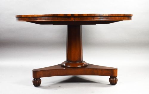 fig 2. A circular Regency tilt-top breakfast table with starburst flame mahogany veneers shown tilted upright on a pedestal base.