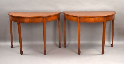 fig 2. A pair of Georgian mahogany demilune console tables featuring semi-circular tops, plain aprons, and square tapered legs.