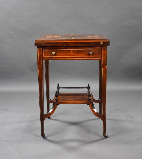 fig 2. An Edwardian inlaid rosewood envelope card table with tapered square legs, brass castors, a lower undertier shelf, and a top split into four triangular leaves.