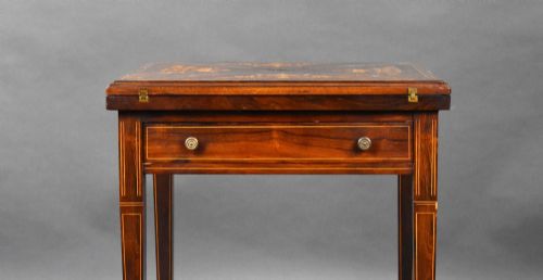 fig 3. An Edwardian inlaid rosewood envelope card table with tapered square legs, brass castors, a lower undertier shelf, and a top split into four triangular leaves.