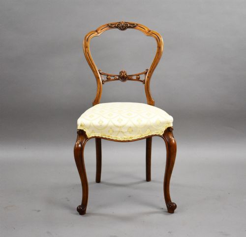 fig 2. A set of four Victorian walnut balloon back dining chairs with carved horizontal splats, cabriole front legs, and cream pattern upholstered seats.