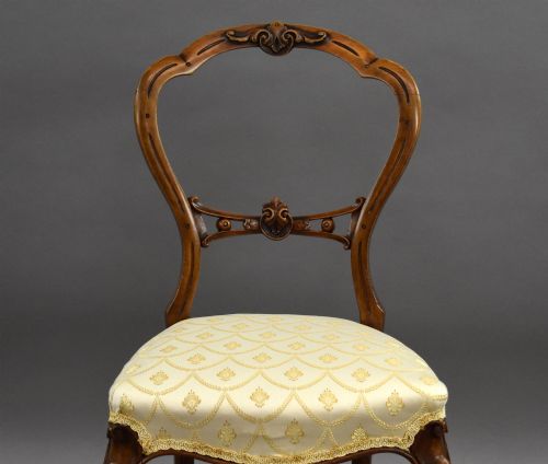 fig 3. A set of four Victorian walnut balloon back dining chairs with carved horizontal splats, cabriole front legs, and cream pattern upholstered seats.