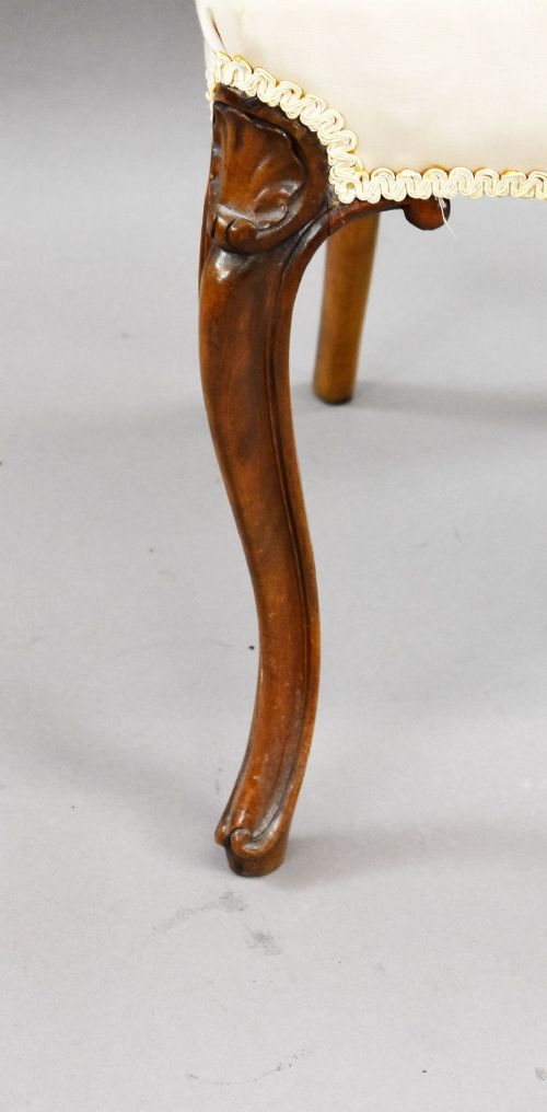 fig 4. A set of four Victorian walnut balloon back dining chairs featuring carved back crests, cabriole front legs, and cream upholstered seats.