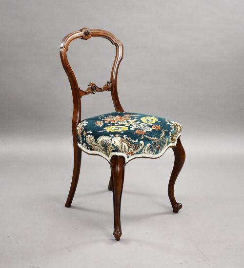 fig 1. A set of six Victorian mahogany dining chairs featuring carved balloon backrests, blue patterned upholstery, and elegant cabriole legs.