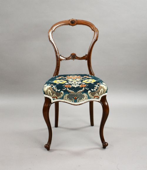 fig 2. A set of six Victorian mahogany dining chairs featuring carved balloon backrests, blue patterned upholstery, and elegant cabriole legs.