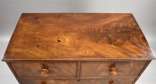 fig 4. A Regency flame mahogany chest of drawers featuring two short over two long drawers with turned timber knobs and shaped bracket feet.