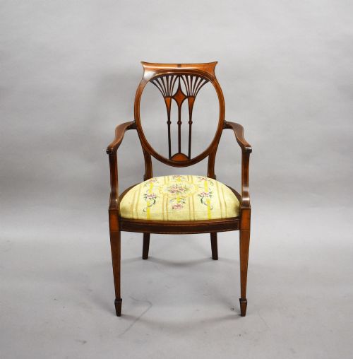 fig 2. A pair of Edwardian Sheraton Revival mahogany armchairs featuring oval backs with vertical fan splats, swept arms, satinwood inlays, and yellow floral upholstered seats.