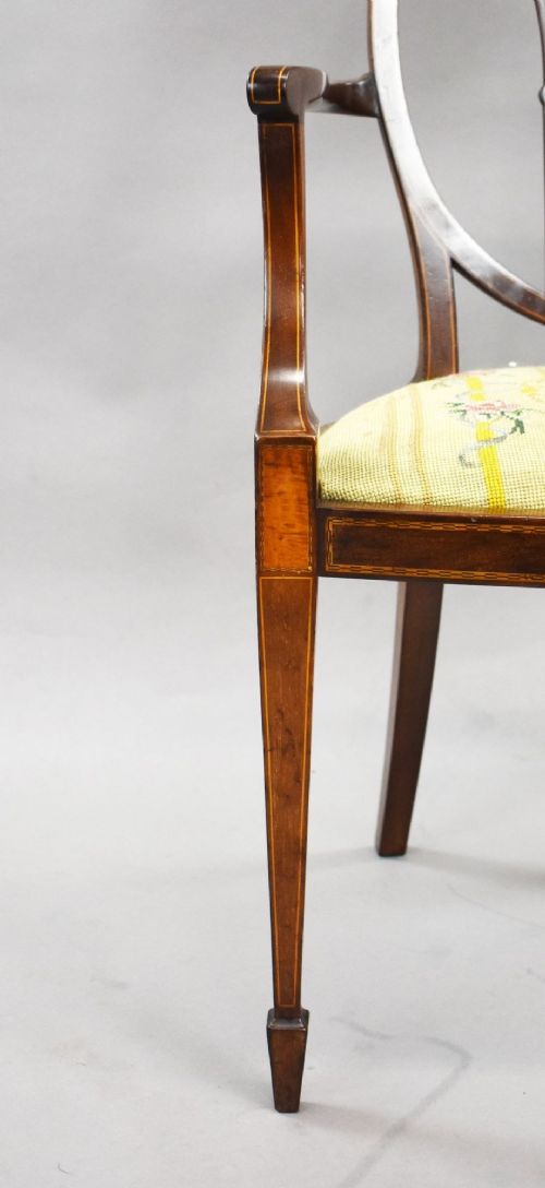 A pair of Edwardian Sheraton Revival mahogany armchairs featuring oval backs with vertical fan splats, swept arms, satinwood inlays, and yellow floral upholstered seats. View VIII