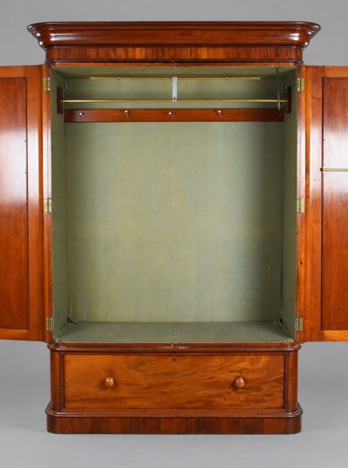 fig 3. A nineteenth-century Victorian mahogany wardrobe featuring two arched mirrored doors above a single full-width drawer with turned wooden knobs.