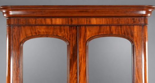 fig 4. A nineteenth-century Victorian mahogany wardrobe featuring two arched mirrored doors above a single full-width drawer with turned wooden knobs.