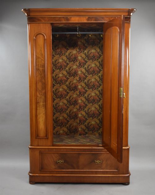 fig 1. Victorian flame mahogany wardrobe featuring a central full-length arched mirror door flanked by arched wood panels, topped with a moulded cornice and resting on a base drawer.