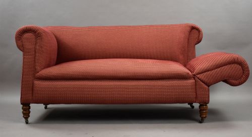 fig 2. A late Victorian upholstered two-seater sofa featuring red striped fabric, scroll arms, and turned wooden legs with brass castors.