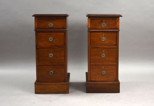 fig 1. A matching pair of narrow Victorian mahogany bedside chests, each featuring four stacked drawers with central brass ring pulls set on a solid plinth base.