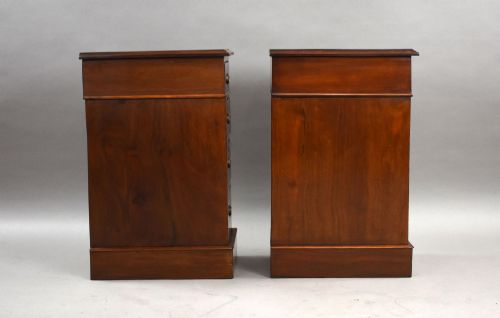 fig 2. A matching pair of narrow Victorian mahogany bedside chests, each featuring four stacked drawers with central brass ring pulls set on a solid plinth base.