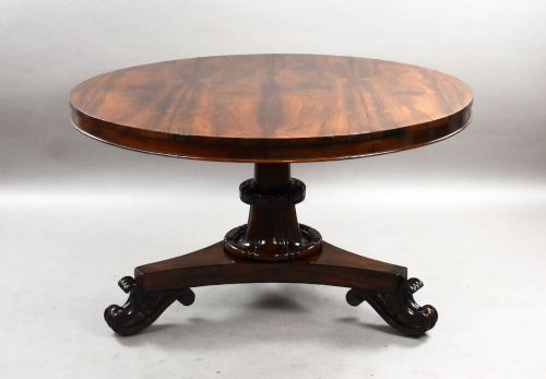 fig 2. A William IV circular rosewood tilt-top breakfast table showing a book-matched grain pattern displayed vertically above a triform base.