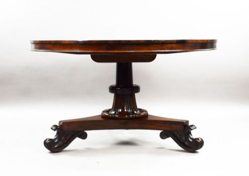 fig 3. A William IV circular rosewood tilt-top breakfast table showing a book-matched grain pattern displayed vertically above a triform base.