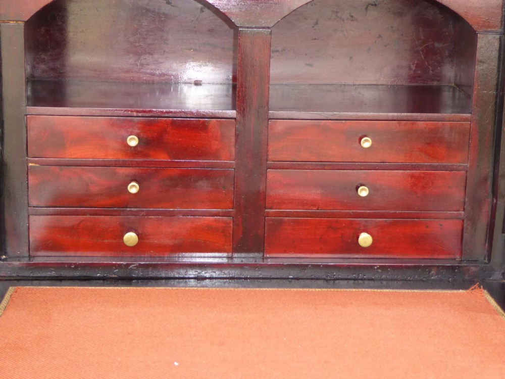 A dark mahogany drop-front escritoire cabinet featuring an open writing flap, fitted interior drawers, brass mounts, a black marble top, and carved paw feet. View IX