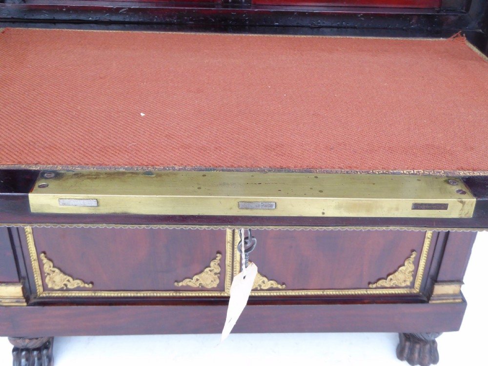 A dark mahogany drop-front escritoire cabinet featuring an open writing flap, fitted interior drawers, brass mounts, a black marble top, and carved paw feet. View XI