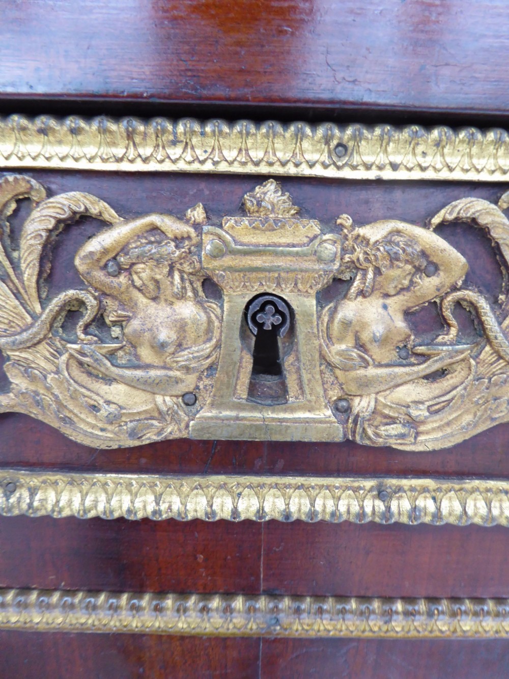 A dark mahogany drop-front escritoire cabinet featuring an open writing flap, fitted interior drawers, brass mounts, a black marble top, and carved paw feet. View XV