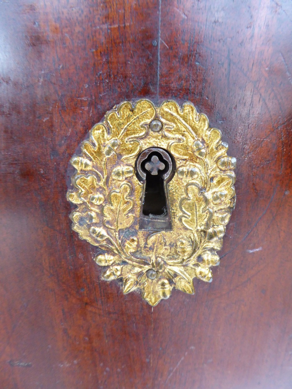 A dark mahogany drop-front escritoire cabinet featuring an open writing flap, fitted interior drawers, brass mounts, a black marble top, and carved paw feet. View XVI