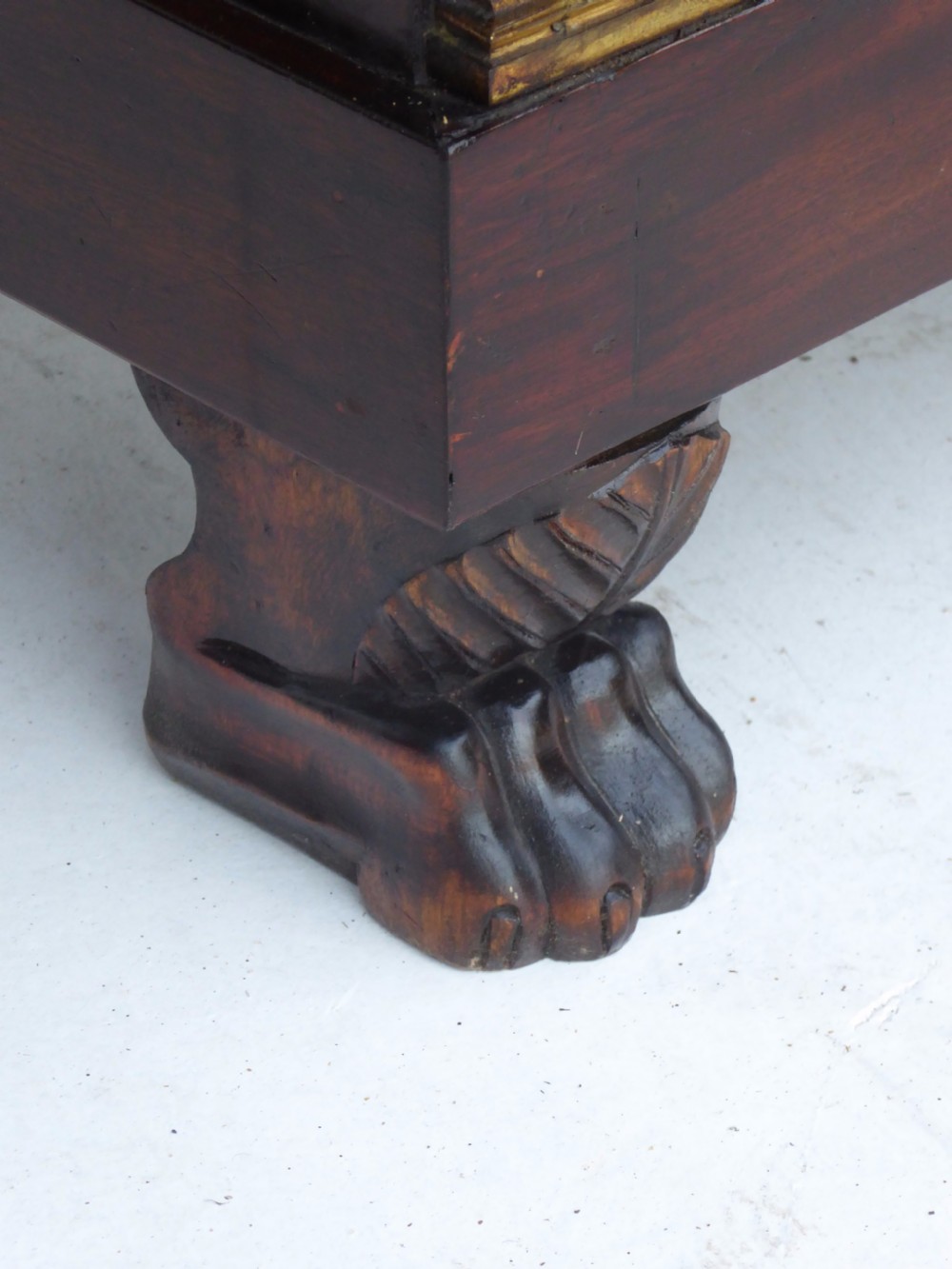 A dark mahogany drop-front escritoire cabinet featuring an open writing flap, fitted interior drawers, brass mounts, a black marble top, and carved paw feet. View XIX