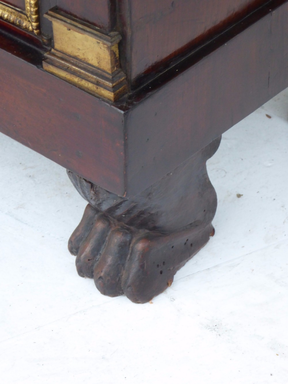 A dark mahogany drop-front escritoire cabinet featuring an open writing flap, fitted interior drawers, brass mounts, a black marble top, and carved paw feet. View XX