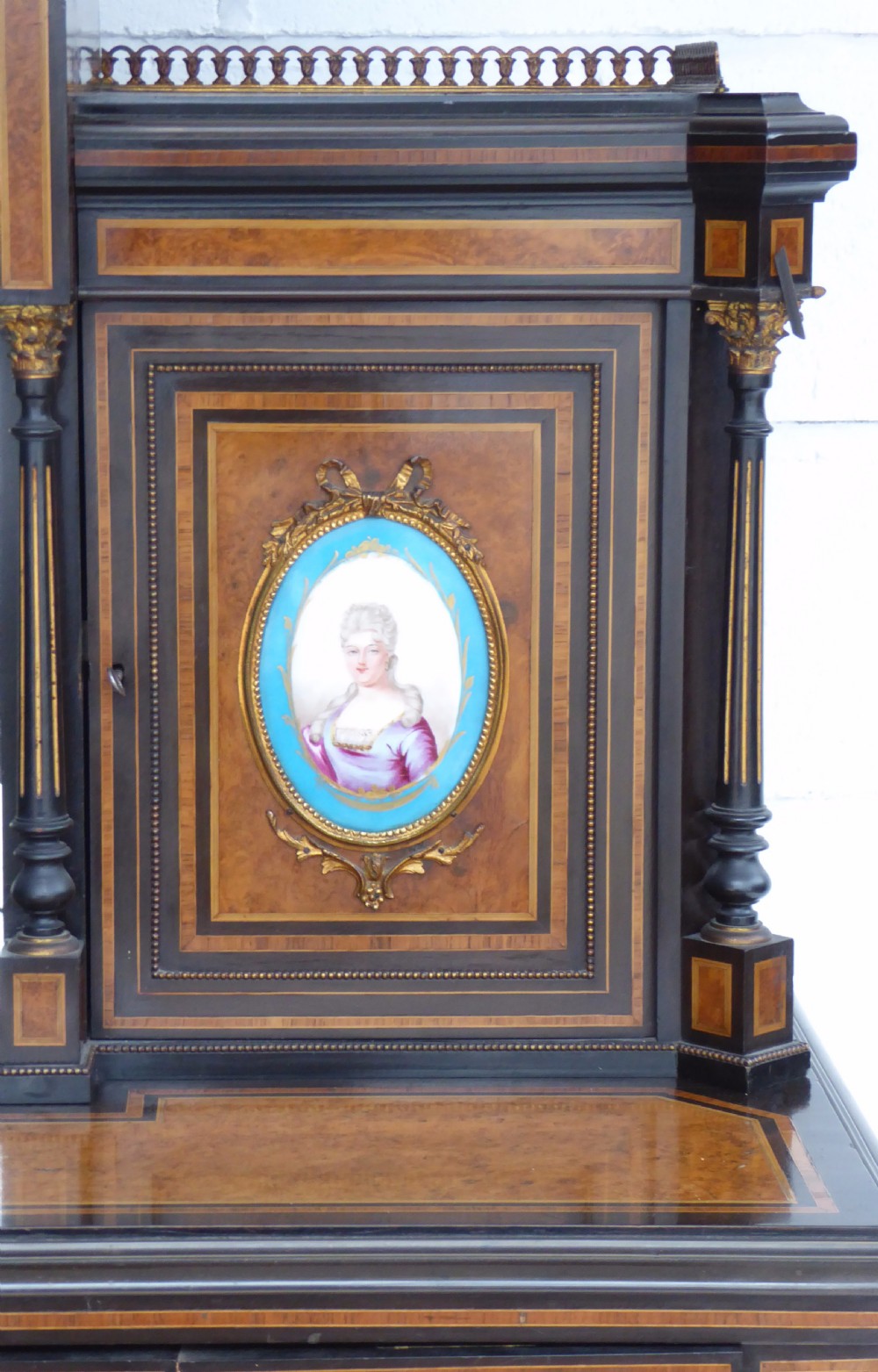 An ebonised and walnut 19th-century Bonheur du Jour writing desk featuring porcelain plaque inserts, gilded mounts, mirrors, and lower tier shelves. View II