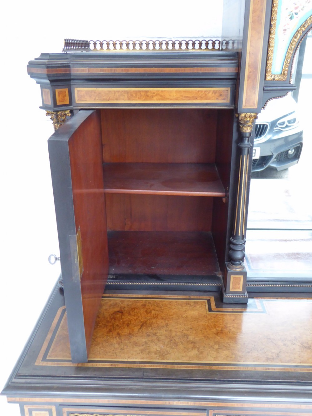 An ebonised and walnut 19th-century Bonheur du Jour writing desk featuring porcelain plaque inserts, gilded mounts, mirrors, and lower tier shelves. View XVIII