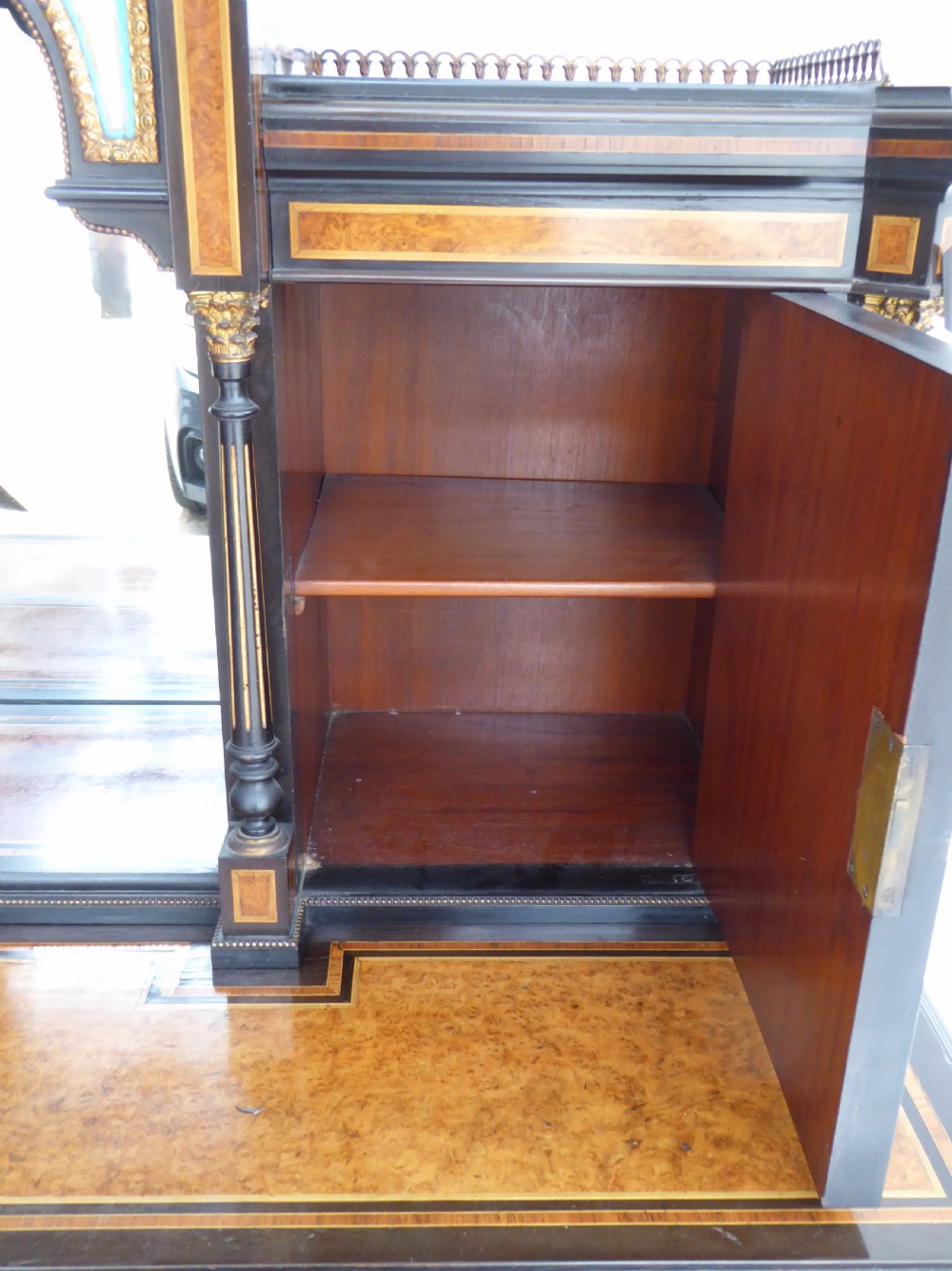 An ebonised and walnut 19th-century Bonheur du Jour writing desk featuring porcelain plaque inserts, gilded mounts, mirrors, and lower tier shelves. View XIX