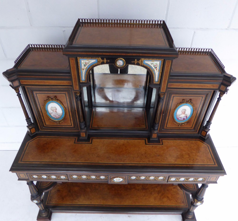 An ebonised and walnut 19th-century Bonheur du Jour writing desk featuring porcelain plaque inserts, gilded mounts, mirrors, and lower tier shelves. View XX