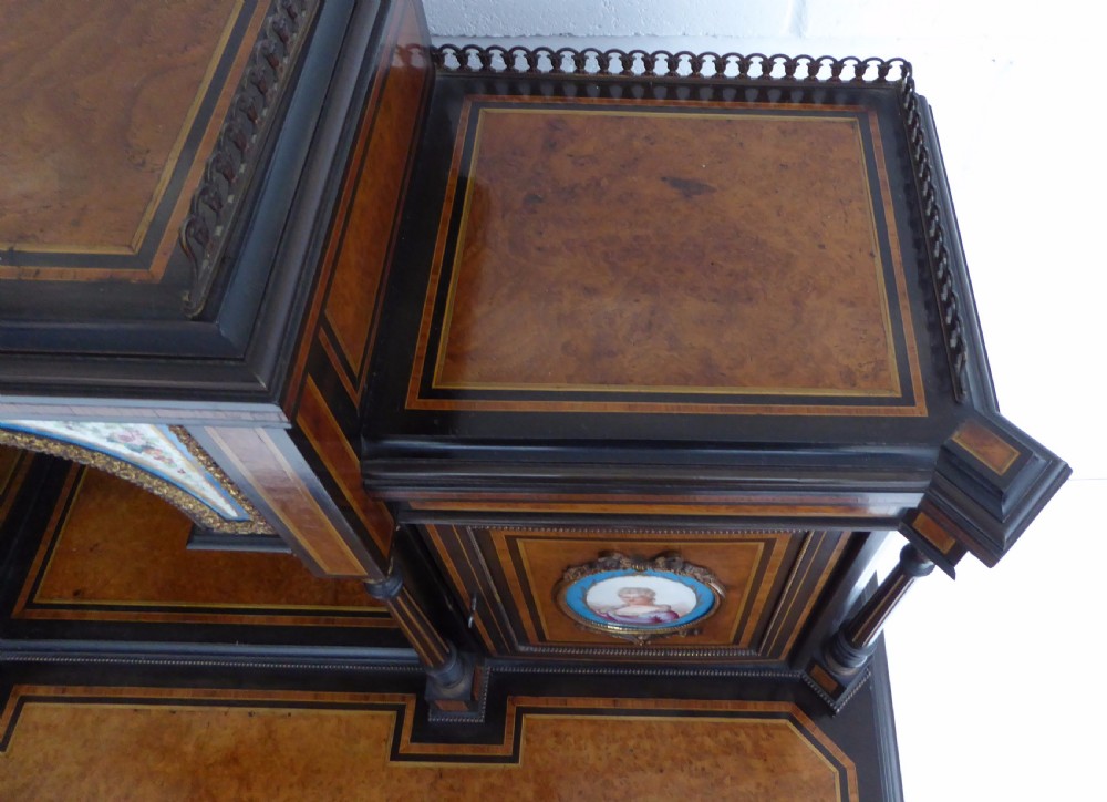 An ebonised and walnut 19th-century Bonheur du Jour writing desk featuring porcelain plaque inserts, gilded mounts, mirrors, and lower tier shelves. View XXIII