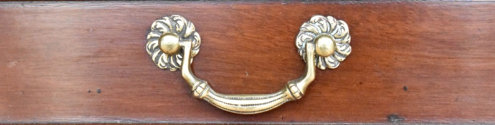 A George III mahogany side table featuring two drawers with brass swan-neck handles and decorative keyhole escutcheons, supported on straight square legs. View III