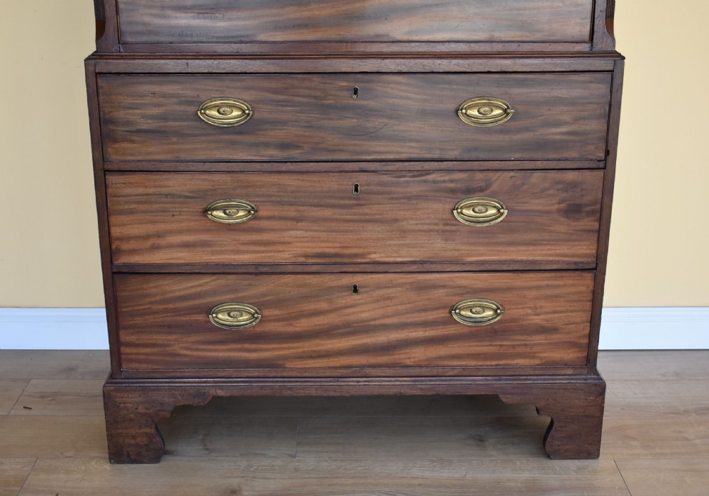 A George III mahogany chest-on-chest featuring a dentil-moulded cornice, fluted chamfered corners, brass oval handles, and bracket feet. View V