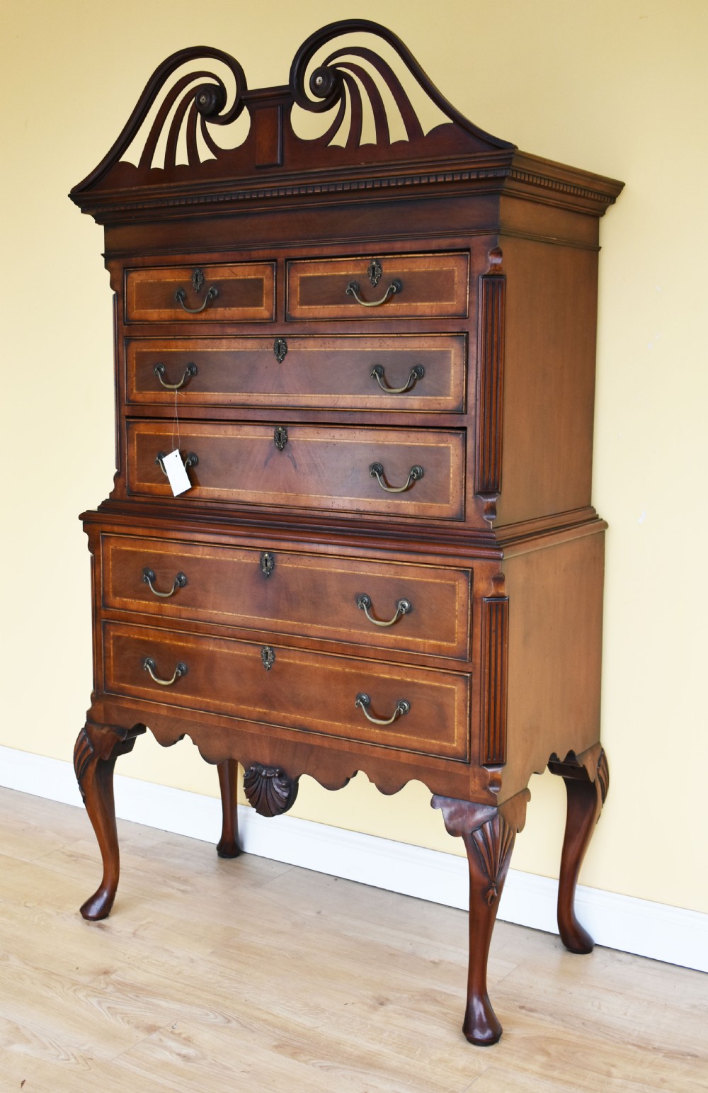 A Georgian style mahogany chest on stand featuring an openwork scrolled pediment, five crossbanded drawers with brass swan-neck handles, and cabriole legs ending in pad feet. View III